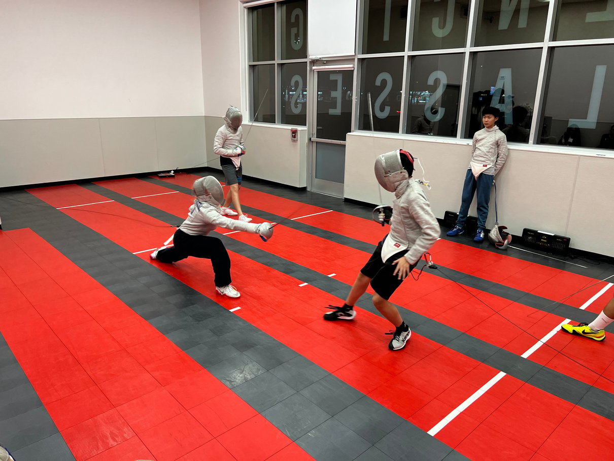 a group of fencers in a gymnasium