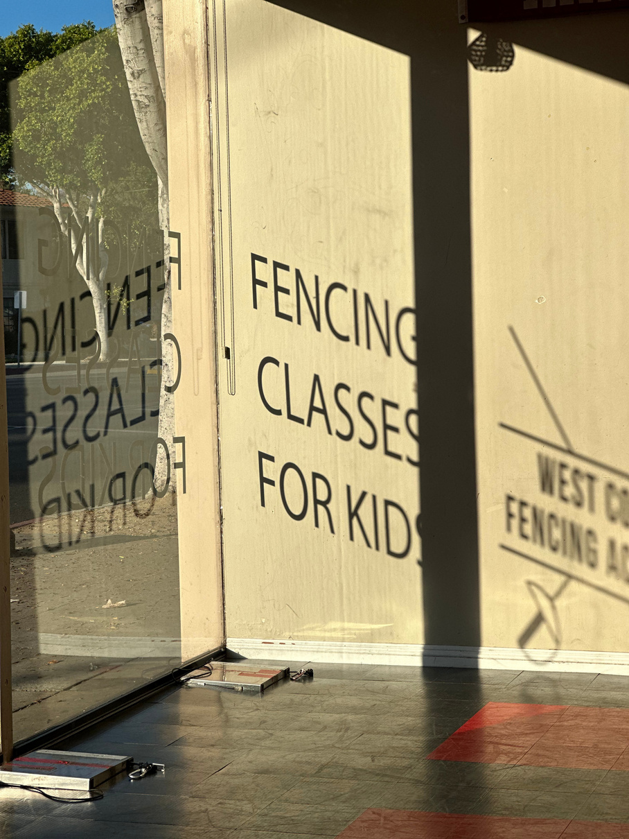 a sign on the window of a building that says fencing classes for kids for West Coast Fencing Academy in Arcadia California and Orange California close to Irvine California