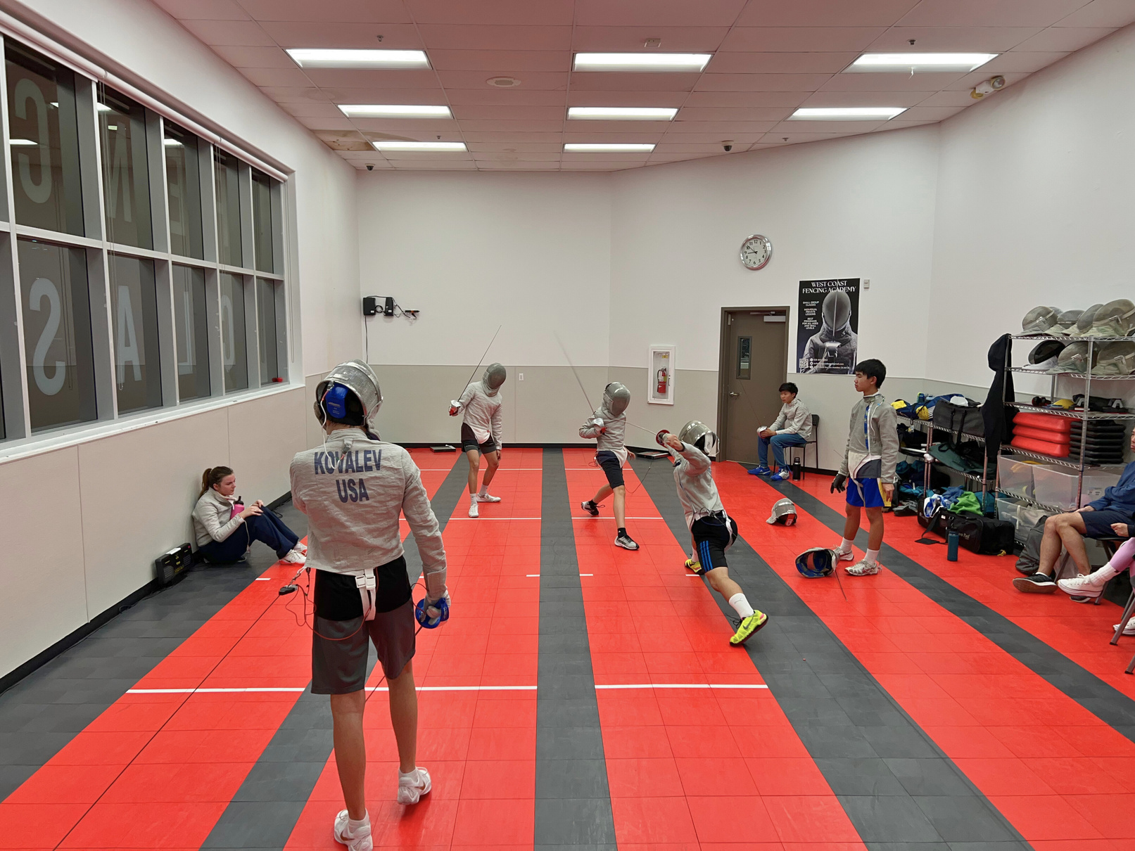 a group of people playing fencing in a gym