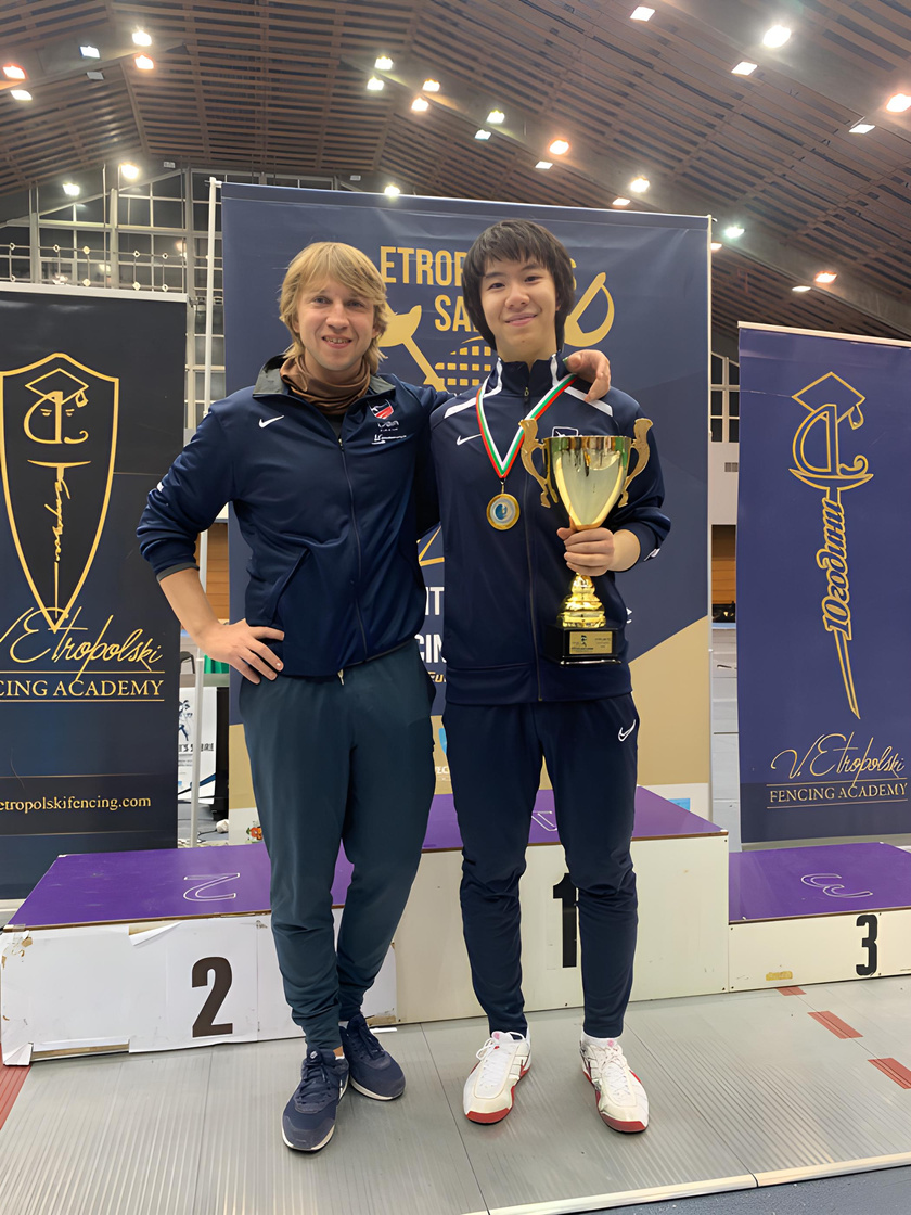 coach nikolay kovalev with fencer connor liang with trophy at a international fencing tournament